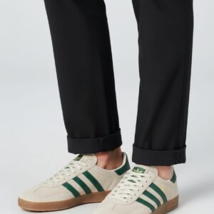 Beyaz zemin üzerinde, bal rengi tabanlı, krem süet ve yeşil detaylı şık spor ayakkabı çifti.