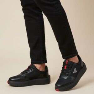 Siyah pantolon ve üçgen logolu siyah sneaker kombini