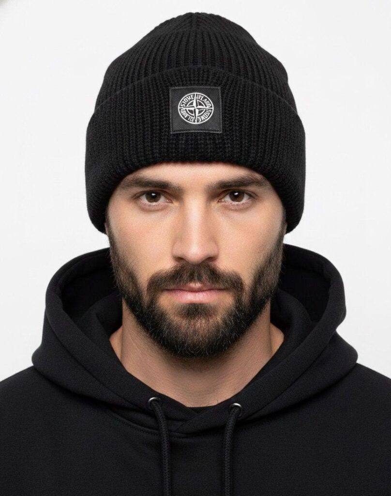 Siyah fitilli örgü ve pusula amblemli bere takan erkek modeli